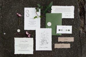 A set of wedding invitations in boho style with calligraphy. Postcard, envelope and card on wedding printing on the background with grass and moss.